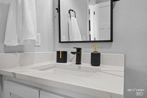 a white bathroom with a sink and a mirror at The Price House in Springdale
