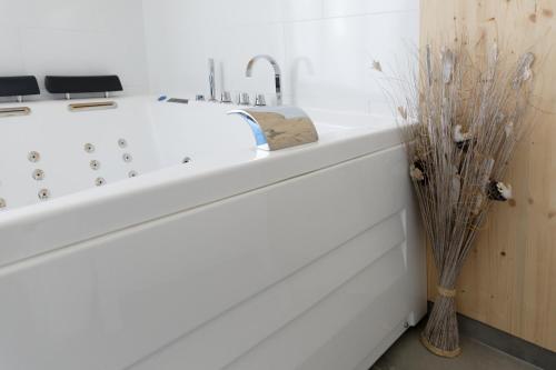 a white bath tub in a bathroom with a vase at Gite Le Cocon de Lily in Saint-Savin-de-Blay
