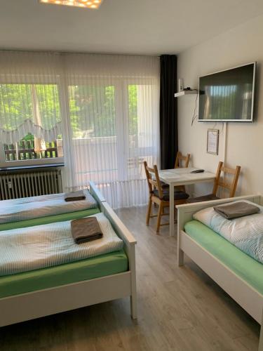a room with two beds and a table with a dining room at Panoramahaus Apartment 7152 in Bad Reichenhall