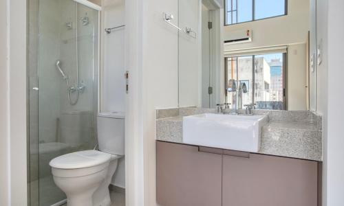 a bathroom with a toilet and a sink and a shower at Tabas - Pivô Match Jardins - Cravinhos in Sao Paulo