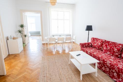 ウィーンにあるComfort Apartments - Stephansdomのリビングルーム(赤いソファ、テーブル付)
