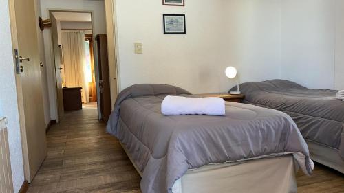 a hotel room with two beds and a table at Loft Catedral by Base 41 in San Carlos de Bariloche