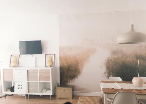 ein Esszimmer mit einem Wandgemälde in der Unterkunft ENCANTADOR apartamento frente a la playa de Bara in Roda de Berà