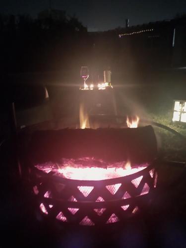 a fire pit at night with a glass of wine at Cabaña Chacras de Caro in Chacras de Coria