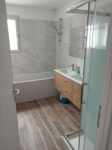 une salle de bain avec une baignoire, un lavabo et une douche dans l'établissement Magnifique maison de plein pied, à Lesperon