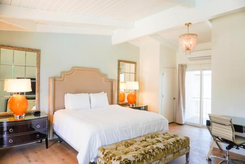 ein Schlafzimmer mit einem großen weißen Bett und einem Stuhl in der Unterkunft Pacific Crest Hotel Santa Barbara in Santa Barbara