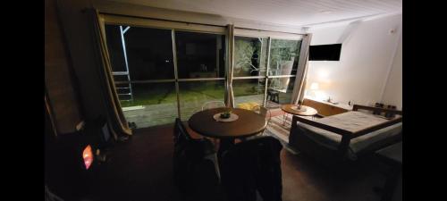 uma sala de estar com uma mesa e uma grande janela em Casa Florida em Villa Serrana