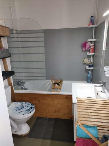 une salle de bain avec une baignoire, des toilettes et un lavabo dans l'établissement Appartement proche plage, à Ouistreham