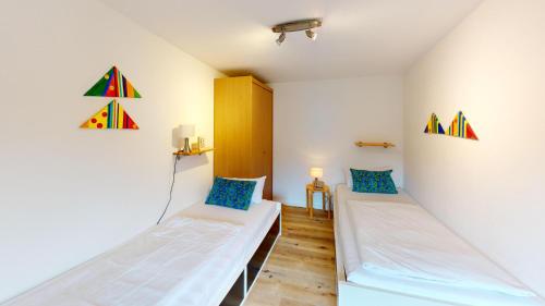 a room with two beds and a wall with kites at Marienleuchte StrandGUT in Westfehmarn