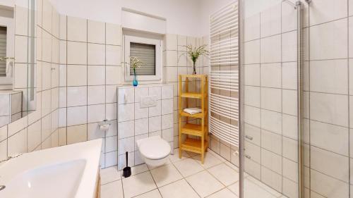 a bathroom with a toilet and a sink and a shower at Marienleuchte StrandGUT in Westfehmarn