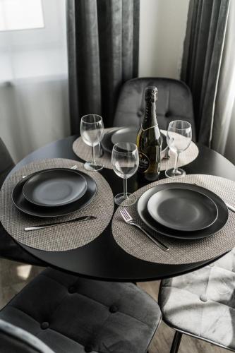 a black table with plates and wine glasses on it at Riverra House in Kaunas