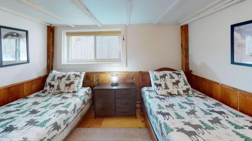 a small room with two beds and a window at Pond View Cabin Brought to you by GetAway Vacations in Chittenden