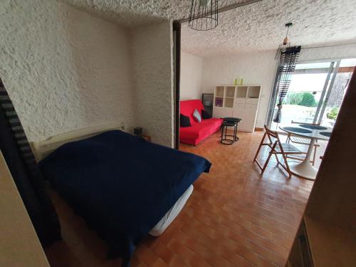 une chambre avec un lit et un canapé rouge dans l'établissement Appartement T1 cabine proche plage, à Lumio