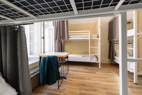 a dorm room with bunk beds and a table at Auberge Internationale de Quebec - HI CANADA in Quebec City