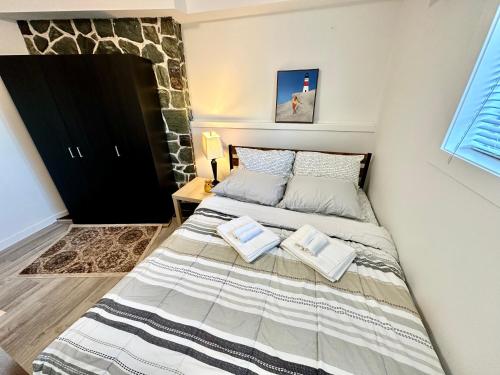 a bedroom with a bed with two pillows on it at Modern Cozy Home W Free Parking- Close to Downtown & Beach in Victoria