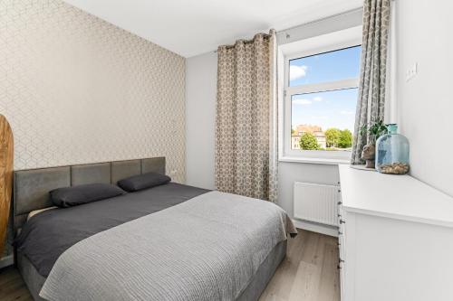 ein Schlafzimmer mit einem Bett und einem Fenster in der Unterkunft Old town apartment Klaipėda free parking in Klaipėda