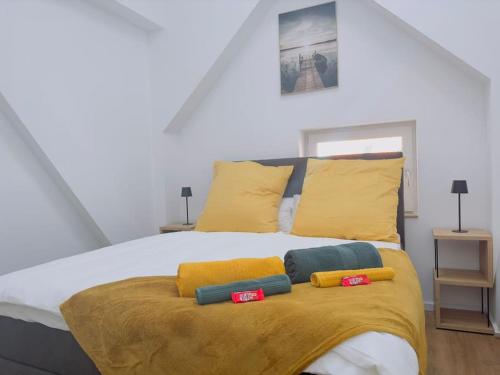 - un lit blanc avec des oreillers jaunes et bleus dans l'établissement Fewo für 3 Personen/Netflix/Parking/WLAN/Stilvoll, à Pöttmes