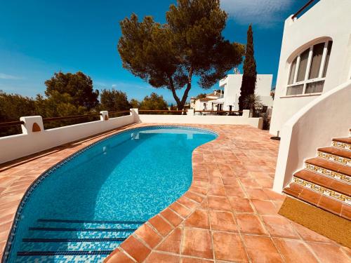 a swimming pool next to a house with a villa at Ibiza Dream Villa Denia, Seaview, Pool, BBQ, Airco, Wifi in Denia