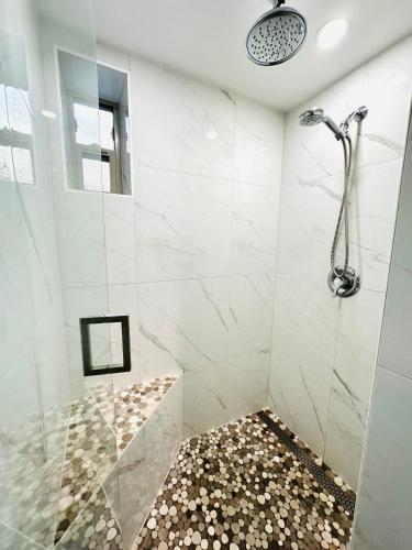 a bathroom with a shower with a glass door at Modern Cozy Home W Free Parking- Close to Downtown & Beach in Victoria