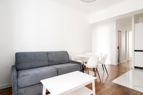 un salon avec un canapé et une table dans l'établissement Appartement Paris Blanche - Welkeys, à Paris