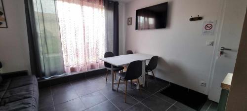 a living room with a table and chairs and a couch at Gite Le Cocon de Lily in Saint-Savin-de-Blay