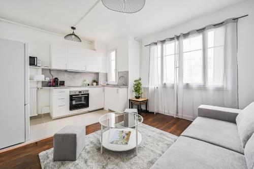 un salon blanc avec un canapé et une table dans l'établissement Skybnb - beau 2 pièces proche Paris - Wifi, à Villejuif