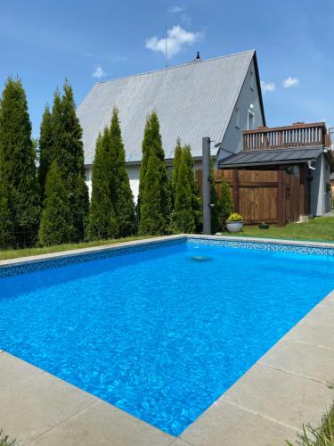 a blue swimming pool in front of a house at Apartmány U Jeřábků in Rapotín