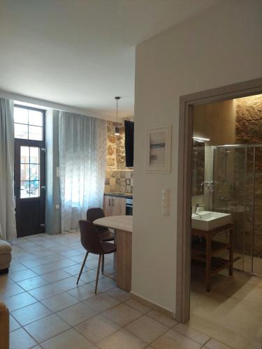 a kitchen with a sink and a table with a chair at Elaion Apartments in Kántanos