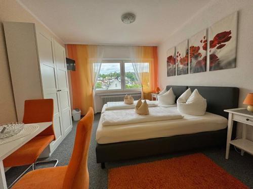 una camera d'albergo con letto, tavolo e sedie di Frühstückspension Zur Krone a Bad Endbach