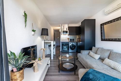 un salon avec un canapé et une table dans l'établissement T2 vue mer Climatisé à 40m de la plage, à Canet