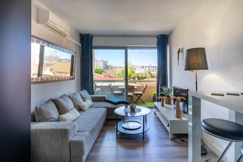 un salon avec un canapé et une table dans l'établissement T2 vue mer Climatisé à 40m de la plage, à Canet