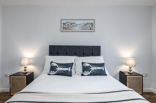 a bedroom with a large bed with two lamps at Cenarth in Benllech