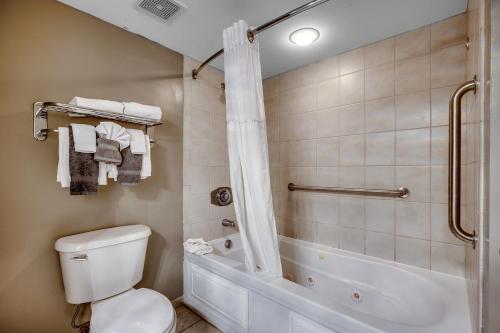 a bathroom with a shower and a toilet and a tub at Stunning Oceanfront King Suite on 18th Floor Centrally Located in Myrtle Beach