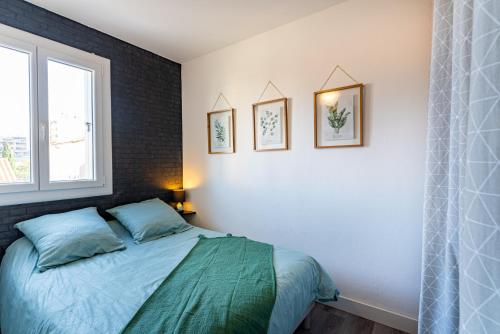 - une chambre avec un lit et trois photos sur le mur dans l'établissement T2 vue mer Climatisé à 40m de la plage, à Canet