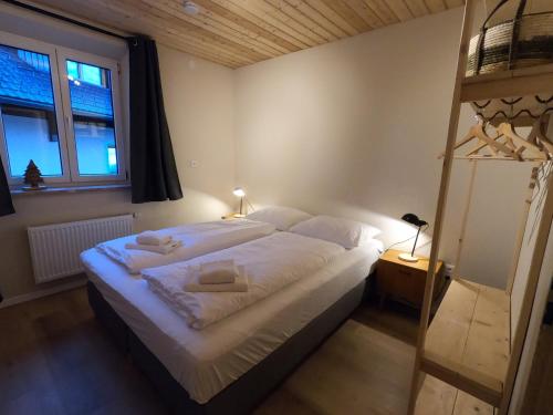 een slaapkamer met een bed met witte lakens en een ladder bij Haus Nampolach 