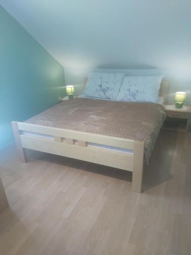 łóżko w pokoju z 2 lampami na podłodze w obiekcie Chata nad kúpaliskom w mieście Kováčová