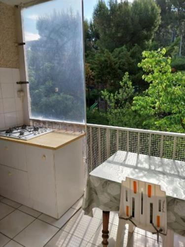 d'un balcon avec une table et une grande fenêtre. dans l'établissement Les Aigues Marines, à Saint-Cyr-sur-Mer