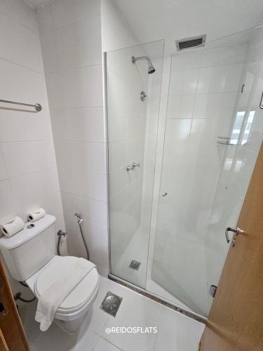 a white bathroom with a shower and a toilet at Flat Saint Moritz Express By Rei dos Flats in Brasilia