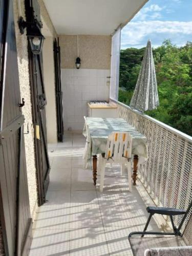 d'une table et de chaises sur un balcon avec une fenêtre. dans l'établissement Les Aigues Marines, à Saint-Cyr-sur-Mer