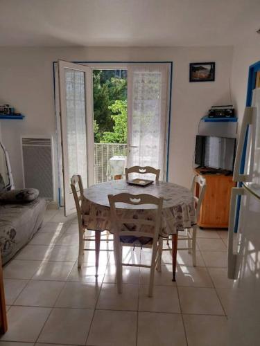- un salon avec une table et des chaises dans l'établissement Les Aigues Marines, à Saint-Cyr-sur-Mer