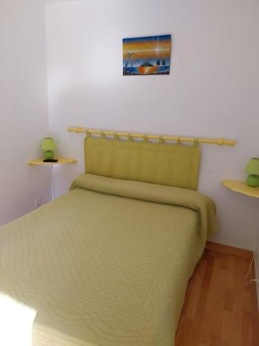 サン・シル・シュル・メールにあるLes Aigues Marinesのベッドルーム1室(緑のベッド1台、壁に棚付)