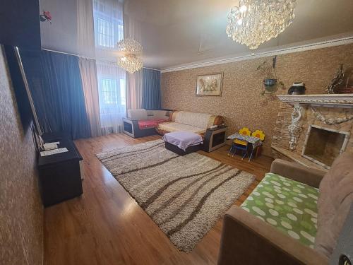 een woonkamer met een bank en een open haard bij Квартира на Набережной in Astana