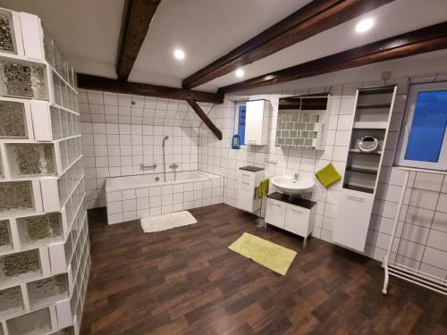 a large bathroom with a tub and a sink at Ferienwohnung „Schau ins Frankenland“ in Burgpreppach