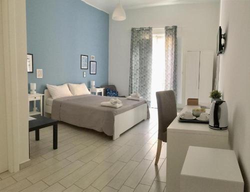 ein Schlafzimmer mit einem Bett und einem Tisch sowie ein Zimmer in der Unterkunft Torrearsa 17 in Trapani