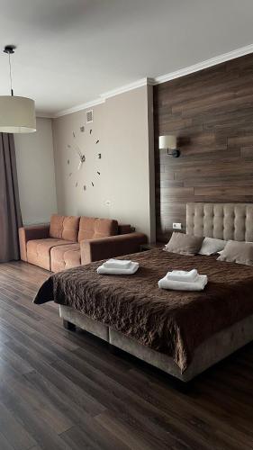 1 dormitorio con 1 cama grande y 1 sofá en Карпати Кайзервальд апарт, en Karpaty