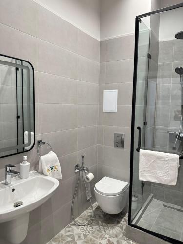 uma casa de banho com um WC, um lavatório e um chuveiro em Five Hotel em Astana