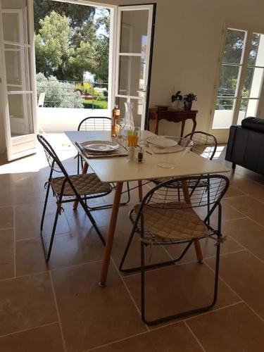 une table à manger et des chaises dans un salon dans l'établissement Cassis Presqu'Ile Calanques 2 pièces neuf, 50 m2, à Cassis