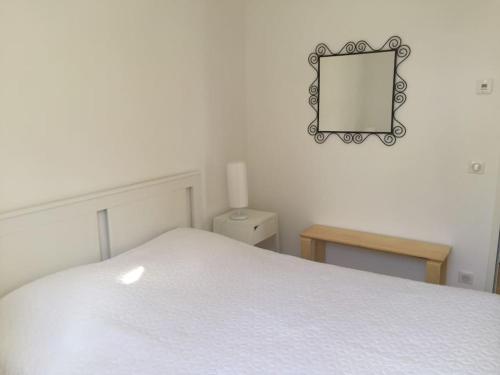 a white bed with a mirror and a table at Cassis Presqu'Ile Calanques 2 pièces neuf, 50 m2 in Cassis