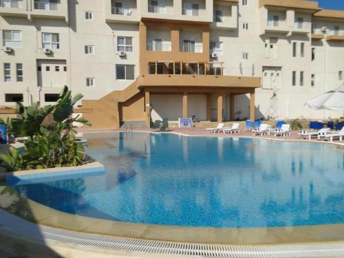 uma grande piscina em frente a um edifício em New Siesta M Hotel em El Alamein