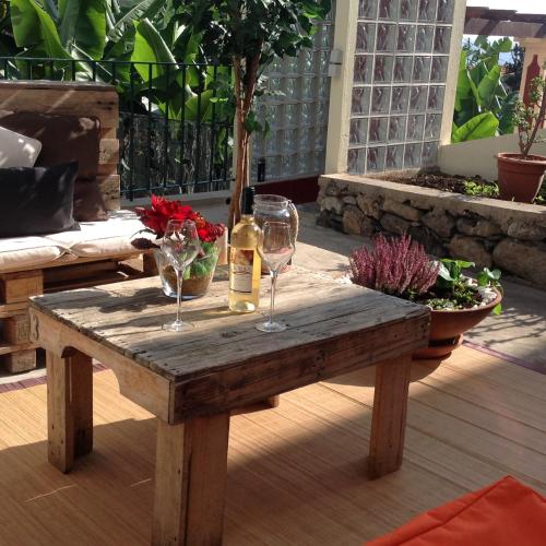 a wooden table with two glasses of wine on it at Apart Monumental in Funchal